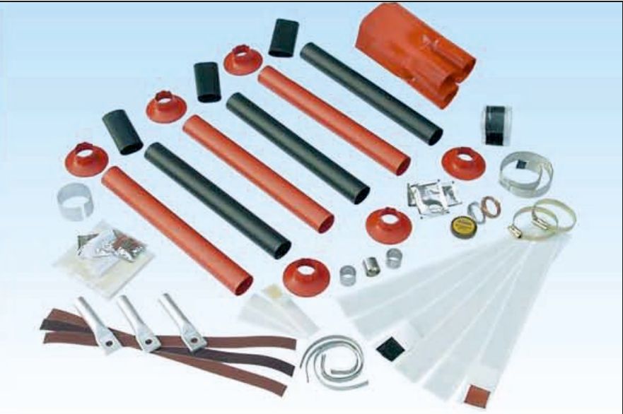 Contents of an 11 kV outdoor termination kit laid out: red non-tracking tubes, black stress-control tubes, red rain sheds, a breakout, lugs, earth braid, clips and tapes