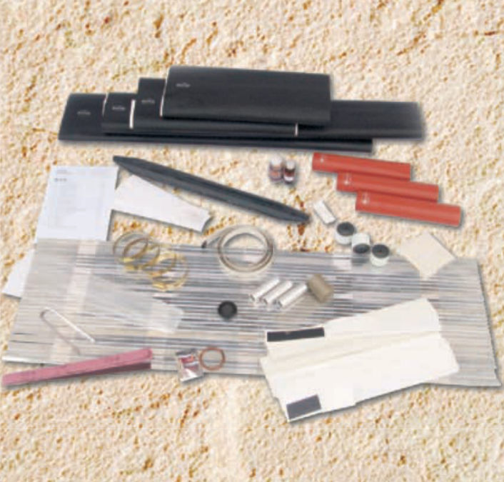 Contents of a GPS/1112 joint kit laid out: black heat-shrink sleeves, red insulating tubes, connectors, mesh, tapes and instructions