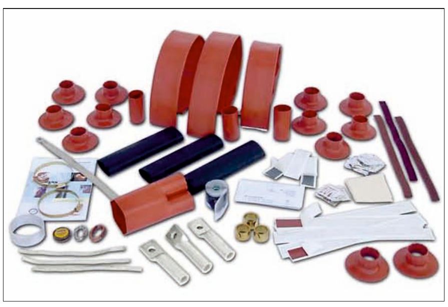 Contents of a GALA 36 kV outdoor termination kit laid out: long red tubes, black tubes, a red three-finger breakout, a dozen red rain sheds, cable lugs, earthing braid, mastic strips and cleaning materials