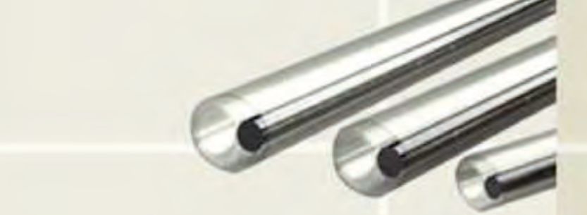 Three clear heat shrink fibre optic splice protection sleeves of different sizes, each with a steel strength rod inside